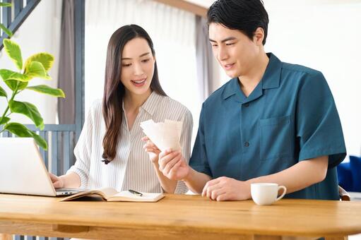 レシートを見て夫婦で家計簿を付ける 夫婦,電卓,家計簿の写真素材