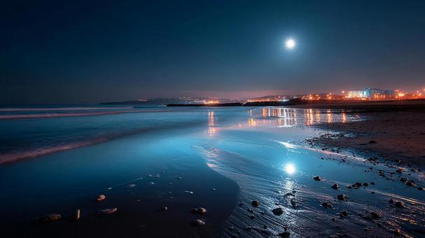光が踊る水面：月明かりが導くビーチの夜の写真