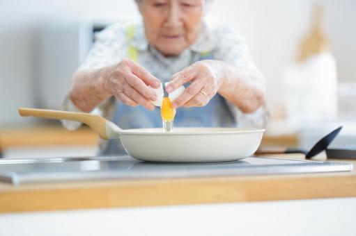 フライパンに卵を割る女性の手元 卵,割る,フライパンの写真素材