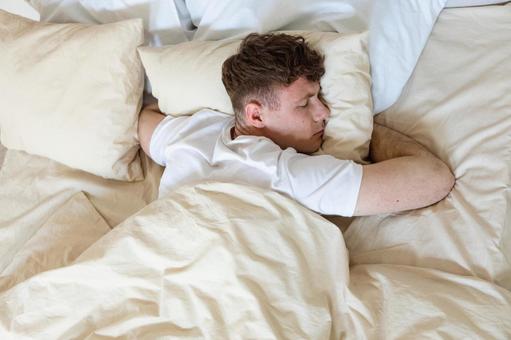 ベッドでうつ伏せで寝る男性 男性,外国人,欧米人の写真素材