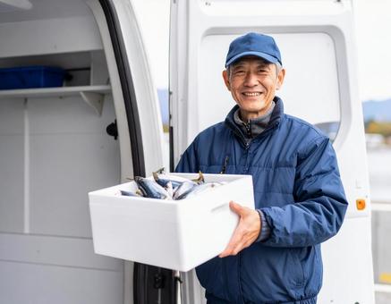 冷蔵トラックに魚介類を積みこむドライバー 冷蔵トラックに魚介類を積みこむドライバーの写真