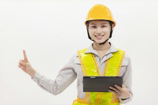 タブレットを使う作業服の女性 タブレットを使う作業服の女性 女性,作業員,ヘルメットの写真素材