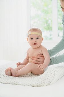脇を支えられカメラ目線でお座りする赤ちゃん 脇を支えられカメラ目線でお座りする赤ちゃん 赤ちゃん,かわいい,お座りの写真素材