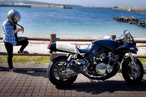 ＜素材＞海辺で休むツーリング中の女の子 女性,悩む,海の写真素材