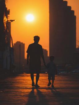 愛と絆の象徴:夕日に向かって歩む親子 愛と絆の象徴:夕日に向かって歩む親子の写真