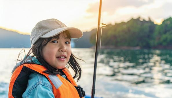  釣りを楽しむライフジャケットの女の子の写真