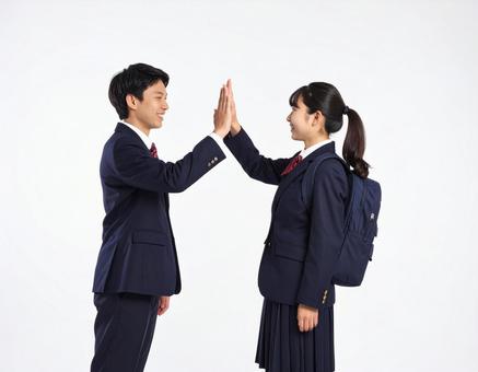 ハイタッチする高校生の男女生徒の写真