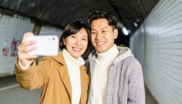 トンネルで記念撮影するカップルの写真