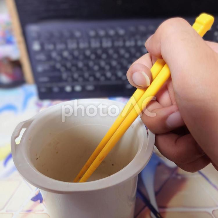 黄色い箸を握る人 手,箸,黄色の写真素材