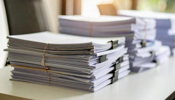 書類まみれの会社の机 書類まみれの会社の机の写真