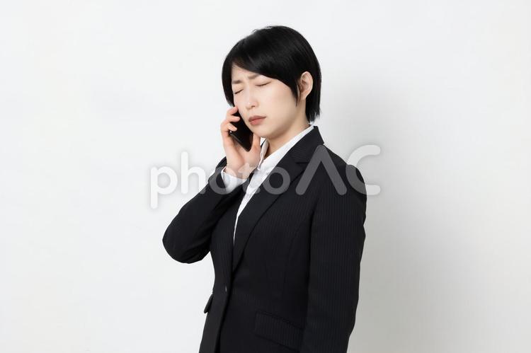 困った顔で電話をしているビジネスウーマン 女,女子,ビジネスウーマンの写真素材