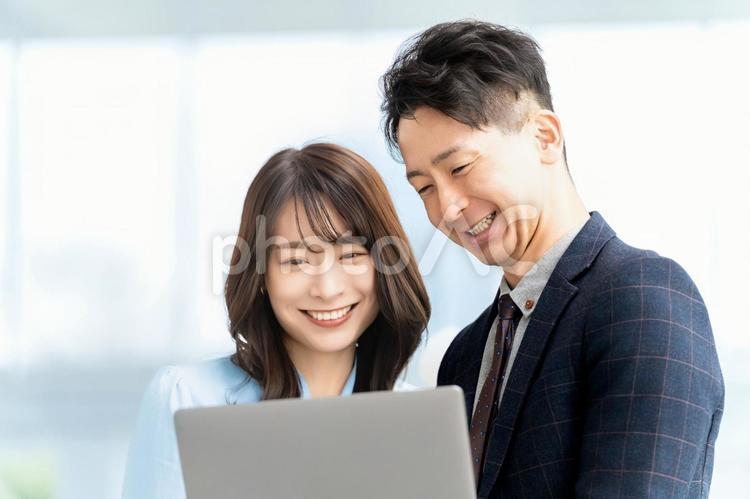 パソコンを見る笑顔の男女ビジネスマン 男性,女性,男女の写真素材