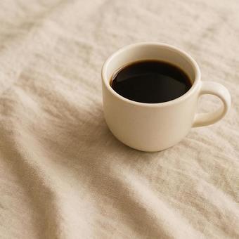 リネンの布の上にコーヒーカップ リネンの布の上にコーヒーカップの写真