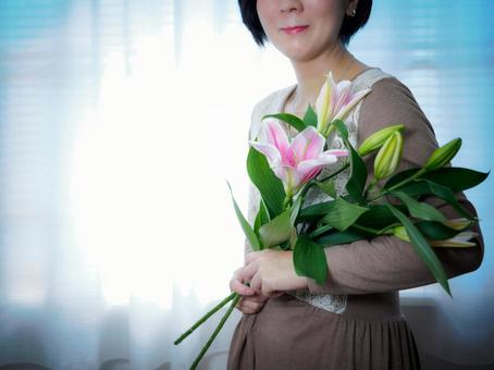 36:ゆりの花を抱いて微笑む女性 36:ゆりの花を抱いて微笑む女性 花,ゆり,丁寧な暮らしの写真素材