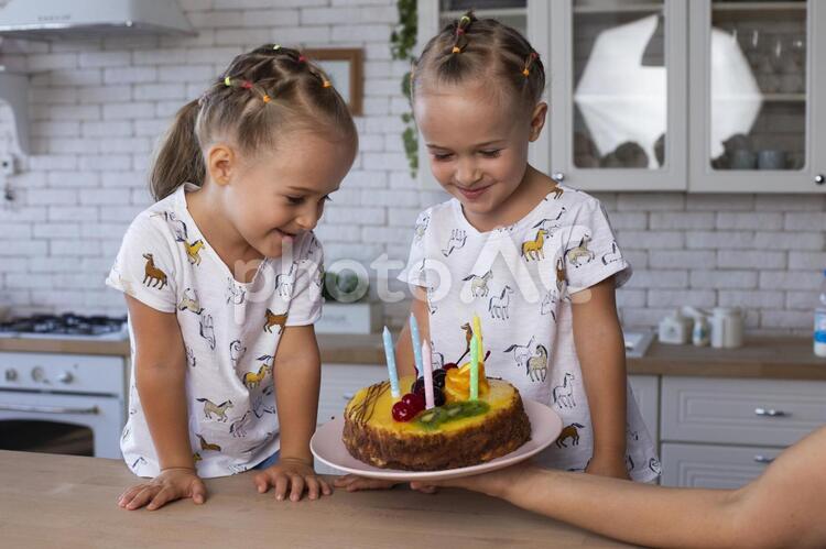 バースデーケーキと双子の女の子 双子,姉妹,女の子の写真素材