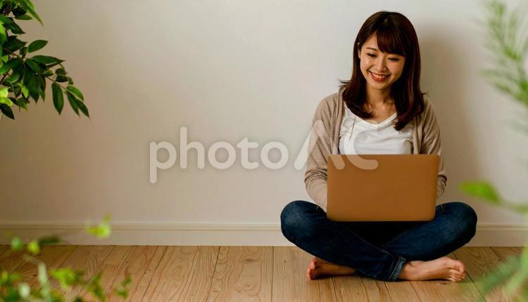 胡坐を組んでパソコン画面を見る女性 ノートパソコン,胡坐,女性の写真素材