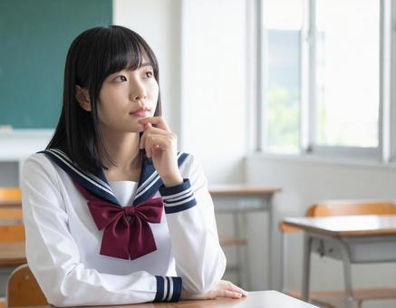 授業中に悩むロングヘアの女子学生 授業中に悩むロングヘアの女子学生の写真