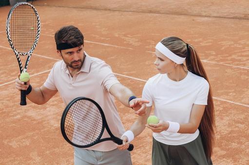 ラケットを構える女性を指導する男性選手 男女,外国人,テニスの写真素材