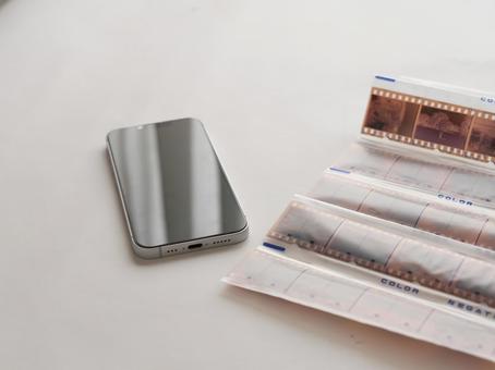 携帯電話とネガフィルム 携帯電話,スマートフォン,ネガフイルムの写真素材