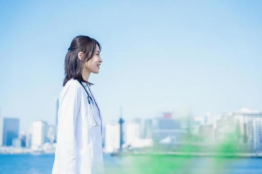 笑顔で外を歩く女性のドクター 笑顔で外を歩く女性のドクター 空,看護師,資格の写真素材