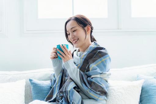 ソファでカップを持つ女性 リラックス,おうち時間,女性の写真素材