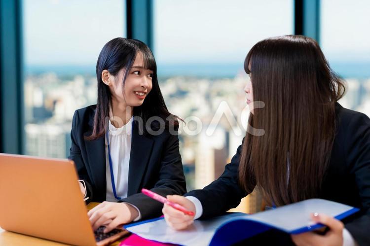仕事中に会話をするビジネスウーマン二人 女性,ビジネス,ビジネスウーマンの写真素材