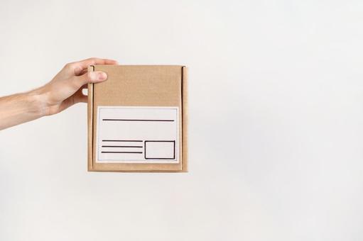 宛名付きの小さい段ボール箱を持つ手 配達,デリバリー,郵便の写真素材