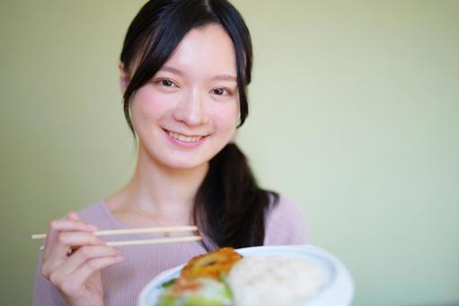 笑顔で料理を見せる女性 女性,食事,食べ物の写真素材
