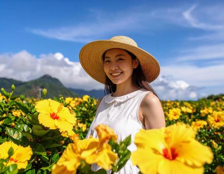 夏旅の彼女・夏空と黄色いハイビスカスの写真