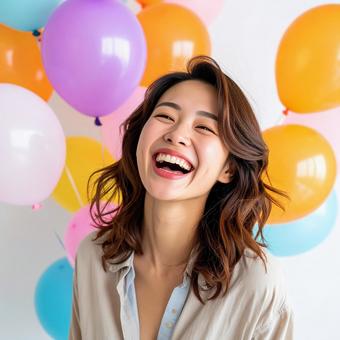 カラフルな風船に囲まれた笑顔の女性の写真