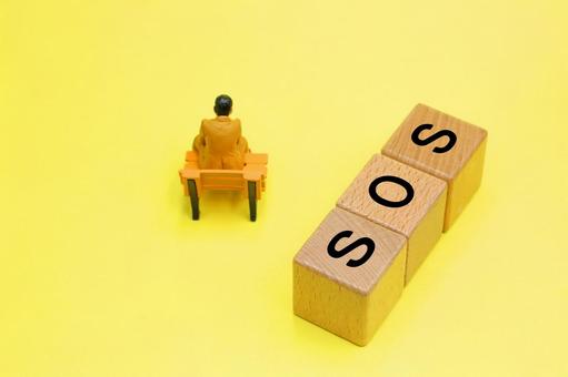 SOSと書かれたブロックと落ち込む人 SOSと書かれたブロックと落ち込む人 sos,悩み,問題解決の写真素材
