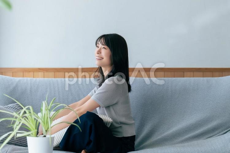 リビングのソファに座る笑顔の女性 女性,ソファ,笑顔の写真素材