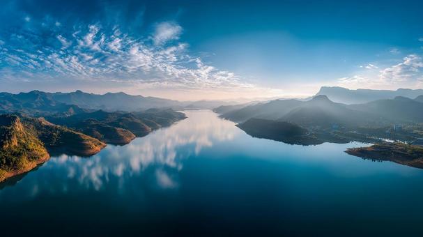 穏やかな湖の畔に広がる、壮大な山脈の景色の写真