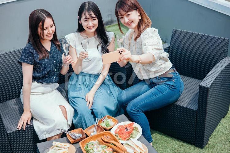 屋上でパーティーをする女性たち（自撮り） 女子会,自撮り,スマホの写真素材