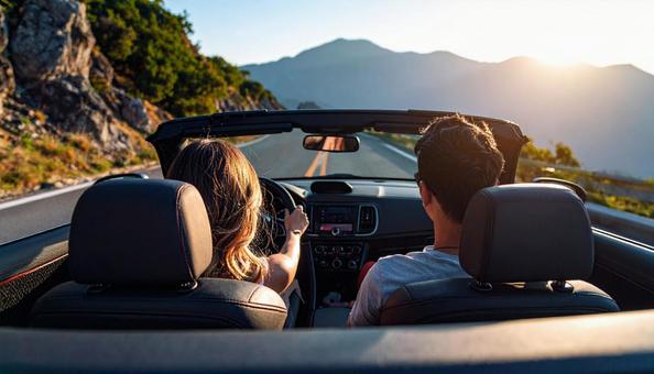 オープンカーに乗ってデートするカップル の写真