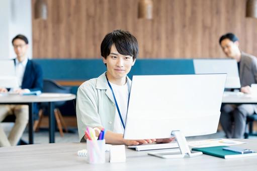 オフィスで働く若いビジネスマン オフィスで働く若いビジネスマンの写真