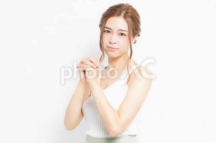 お願いのジェスチャーをする若い女性 女性,お願い,ポーズの写真素材