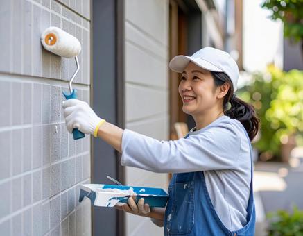 DIYで外壁塗装する女性 DIYで外壁塗装する女性の写真