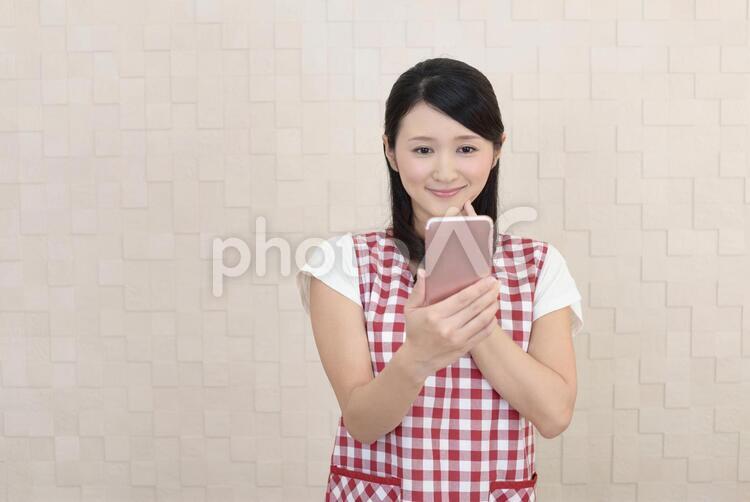 スマートフォンを持つ笑顔の女性 女性,主婦,女の写真素材
