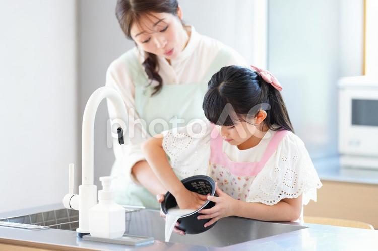 とぎ汁を捨てる女の子 娘,母,米研ぎの写真素材