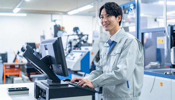 工場の三次元測定機を使う作業服の男性 工場の三次元測定機を使う作業服の男性の写真