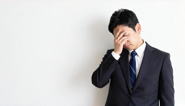 ストレスで顔をおおう日本人ビジネスマン ストレスで顔をおおう日本人ビジネスマンの写真