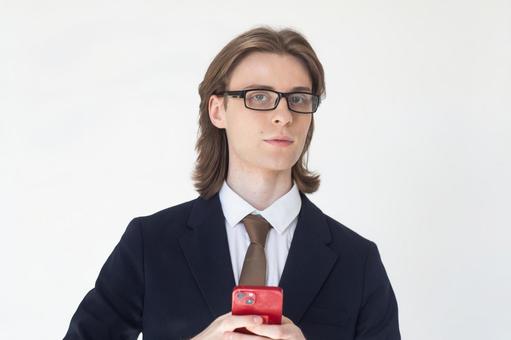 スマートフォンを使うスーツのカメラ目線の男性 男性,外国人,欧米人の写真素材