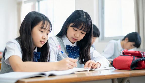 塾で勉強する笑顔の日本人の女の子の写真