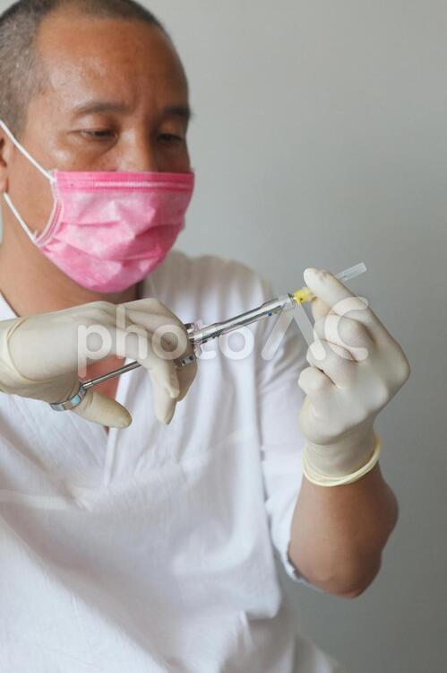 注射器を持つ歯科医 歯医者,歯科医,男性の写真素材