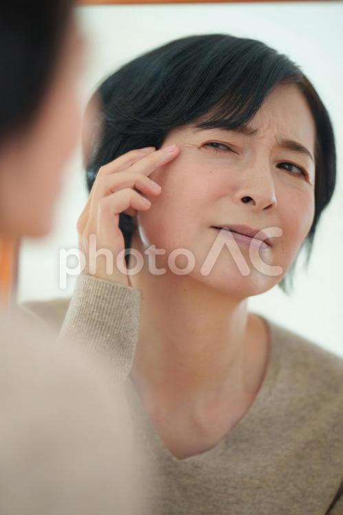鏡で目元を気にする更年期の女性 更年期,女性,日本人の写真素材