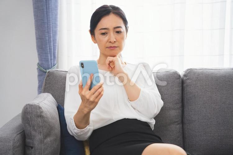携帯を見るミドルの日本人女性 女性,ビジネス,ビジネスウーマンの写真素材