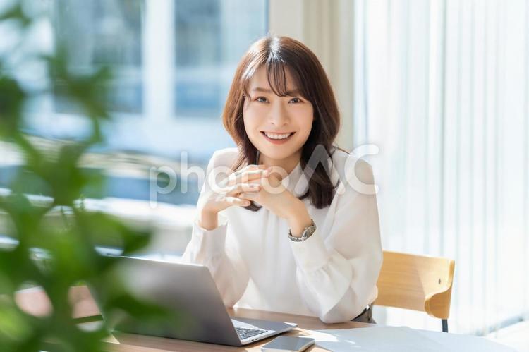デスクワークをする笑顔のビジネスウーマン 女性,ビジネス,パソコンの写真素材
