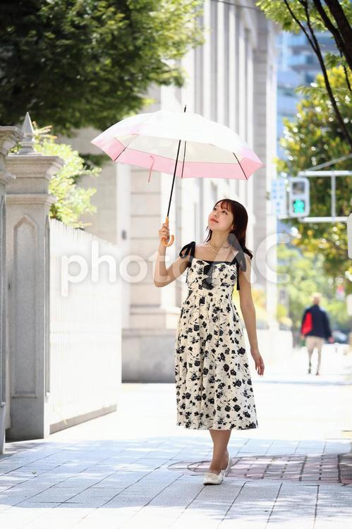 日傘をさして舗道を歩く女性 女性,美人,日傘の写真素材