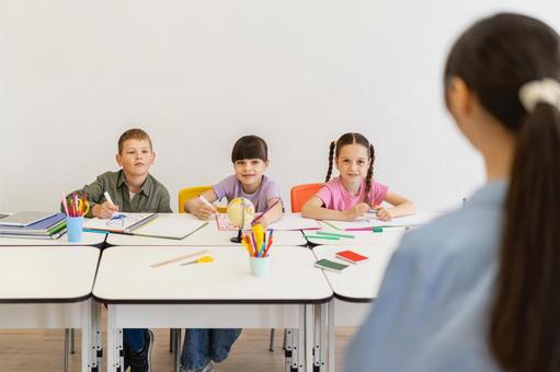 勉強する生徒たちと先生の後ろ姿 女性,女の子,男の子の写真素材